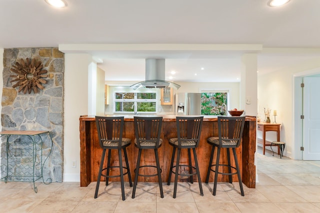 10 Westerly Dr, Bourne, MA 02532 - bar with recessed lighting, island range hood, stainless steel fridge, and light tile patterned flooring