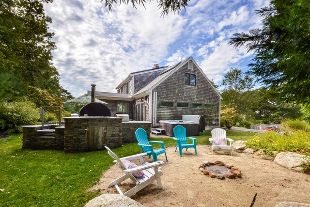 10 Westerly Dr, Bourne, MA 02532 - back of property featuring a hot tub, a patio area, an outdoor fire pit, and area for grilling