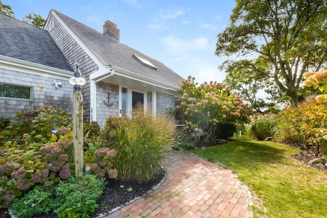 10 Westerly Dr, Bourne, MA 02532 - view of home's exterior featuring a yard, roof with shingles, and a chimney