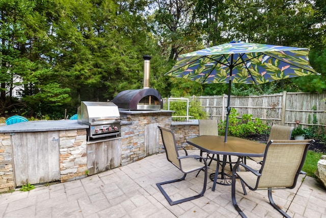 10 Westerly Dr, Bourne, MA 02532 - view of patio with fence, outdoor dining space, exterior kitchen, and area for grilling