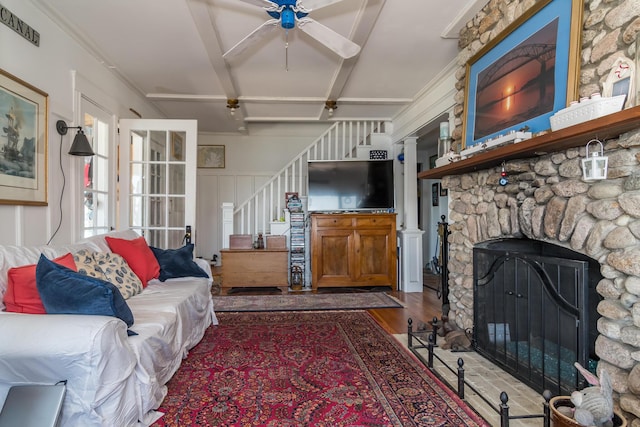 living room with a ceiling fan, stairway, wood finished floors, and a fireplace