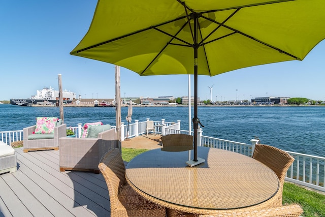 dock area with a deck with water view and outdoor dining area