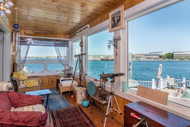 sunroom featuring wood finished floors, a water view, and wooden ceiling
