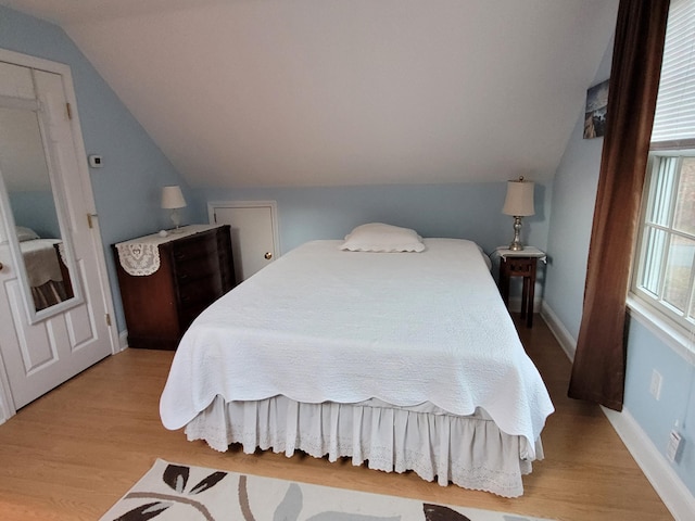 bedroom featuring vaulted ceiling and light hardwood / wood-style flooring