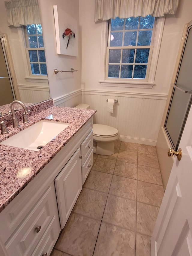 full bathroom with vanity, tile patterned flooring, shower / bath combination with glass door, and toilet