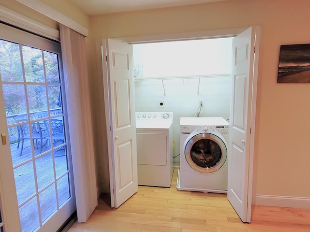 laundry area with washer and clothes dryer and light hardwood / wood-style flooring