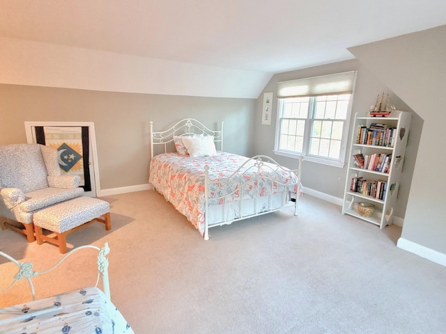 carpeted bedroom with lofted ceiling