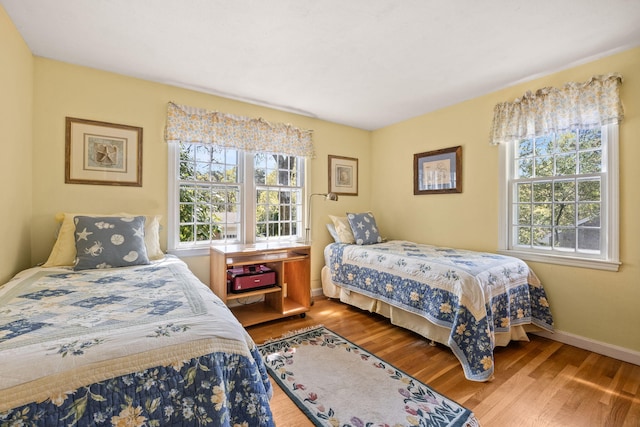 54 Mcnamara Ave, West Yarmouth, MA 02673 - bedroom featuring multiple windows, wood finished floors, and baseboards