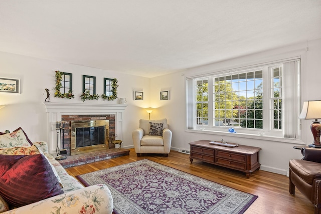 54 Mcnamara Ave, West Yarmouth, MA 02673 - living room with wood finished floors, a brick fireplace, and baseboards