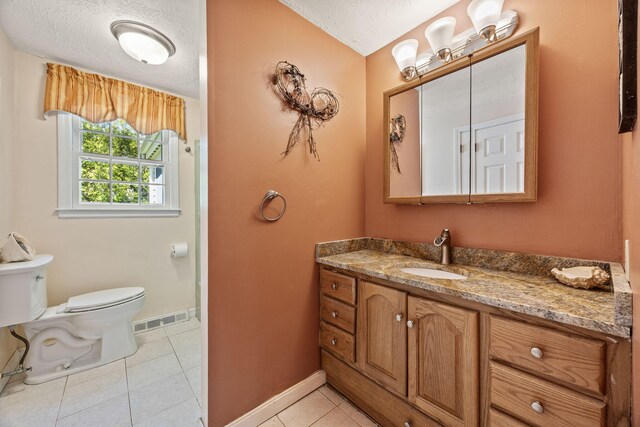 54 Mcnamara Ave, West Yarmouth, MA 02673 - bathroom featuring toilet, vanity, baseboards, tile patterned floors, and a textured ceiling