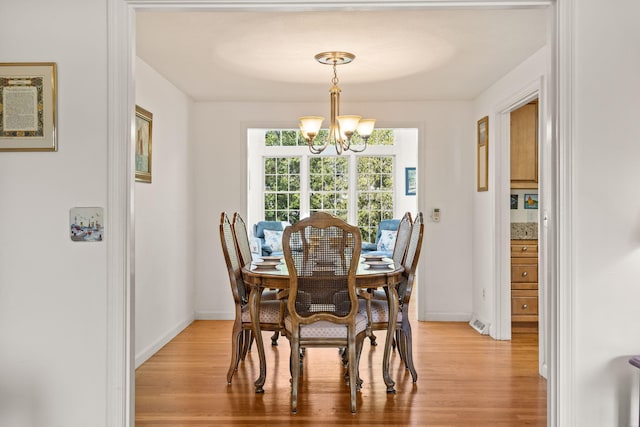 54 Mcnamara Ave, West Yarmouth, MA 02673 - dining room featuring a chandelier, light wood-type flooring, and baseboards