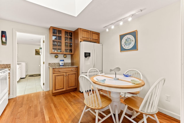 54 Mcnamara Ave, West Yarmouth, MA 02673 - dining room with washer and dryer, light wood-type flooring, track lighting, and a skylight