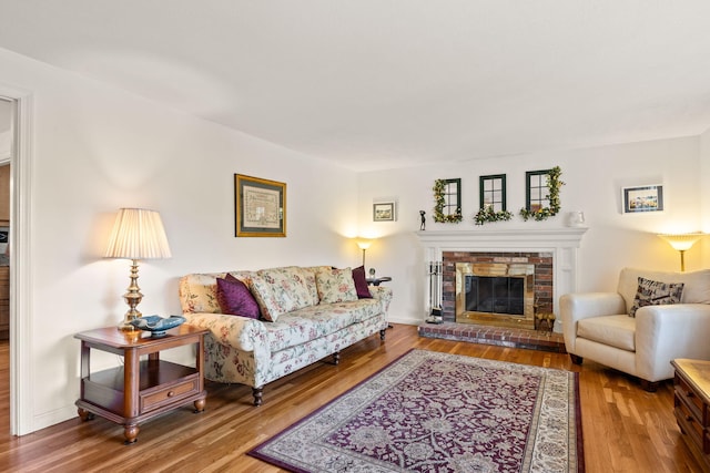 54 Mcnamara Ave, West Yarmouth, MA 02673 - living area featuring wood finished floors and a brick fireplace