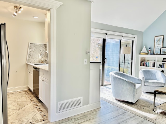 interior space with visible vents, baseboards, light countertops, appliances with stainless steel finishes, and a sink