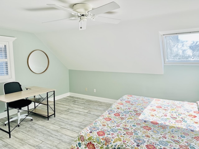 bedroom featuring a ceiling fan, lofted ceiling, baseboards, and wood finished floors