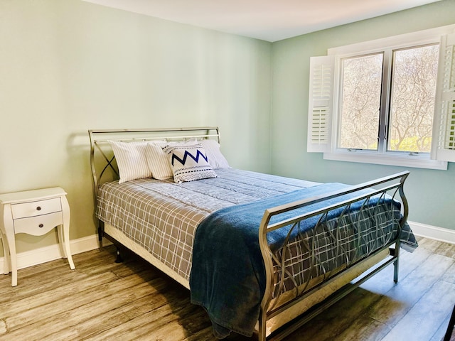 bedroom featuring baseboards and wood finished floors