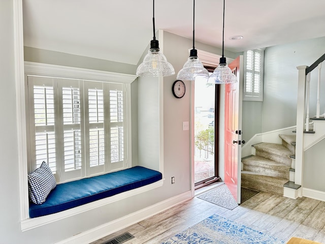 entryway with stairway, wood finished floors, and baseboards