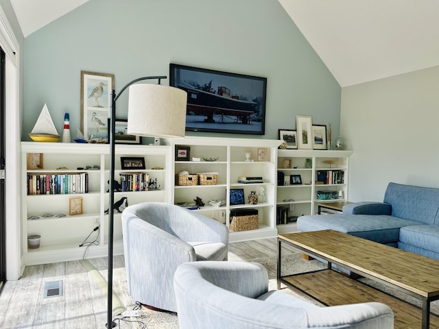 living room with lofted ceiling, wood finished floors, and visible vents