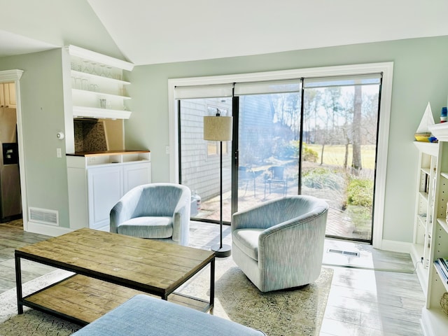 living room with lofted ceiling, baseboards, and visible vents