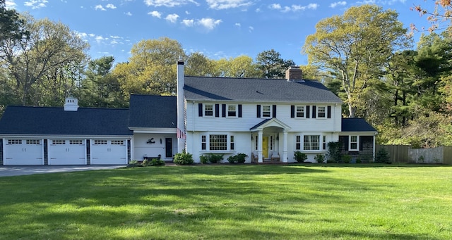 211 Pleasant St, South Yarmouth, MA 02664 - colonial-style house featuring a garage, concrete driveway, a chimney, and view of scattered trees