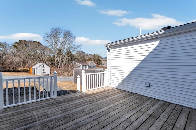 wooden terrace with a storage shed and an outdoor structure