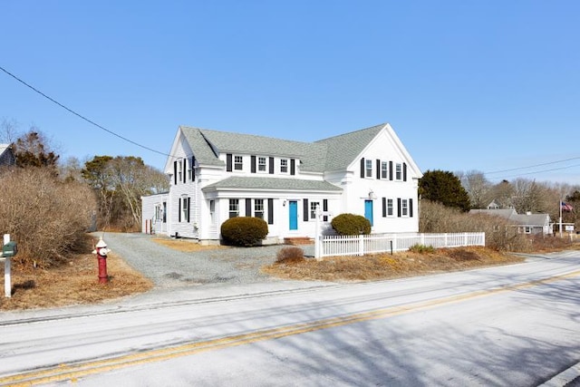 view of front of home featuring gravel driveway and fence