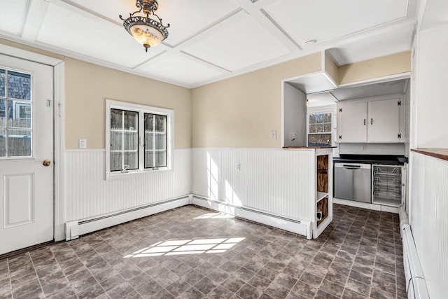 kitchen featuring wainscoting, dark countertops, white cabinetry, a baseboard heating unit, and stainless steel dishwasher