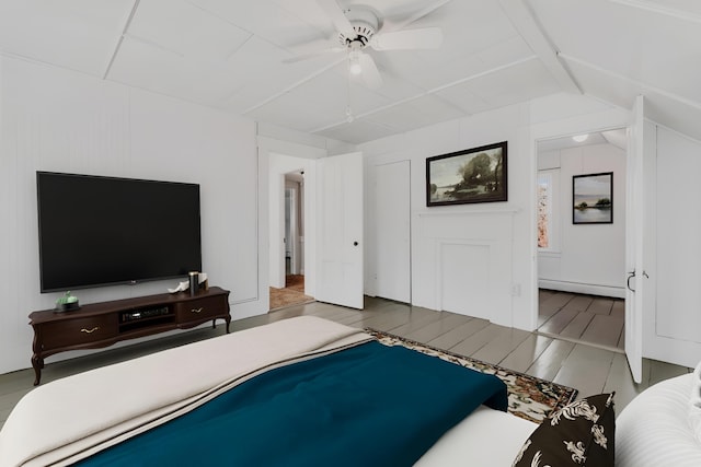 bedroom featuring lofted ceiling, light wood finished floors, a baseboard radiator, and a ceiling fan