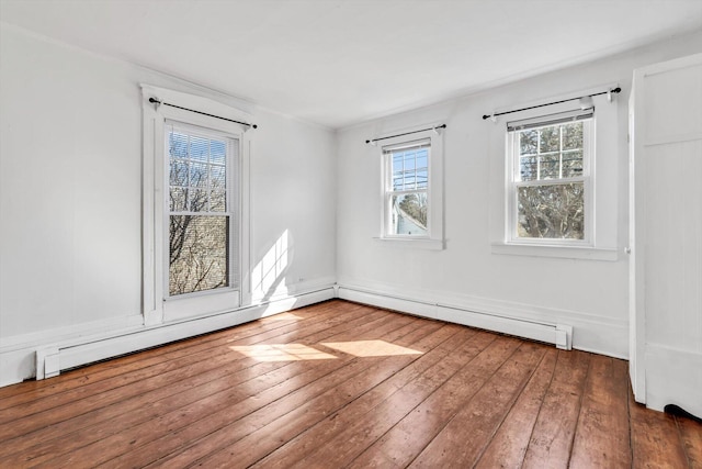 empty room with baseboard heating and hardwood / wood-style floors