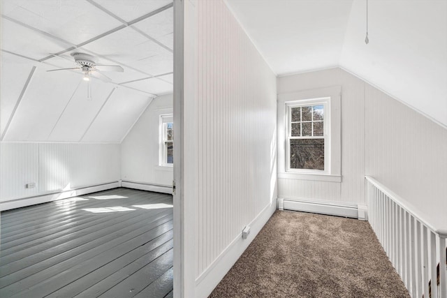 additional living space with a baseboard heating unit, lofted ceiling, a wealth of natural light, and a ceiling fan