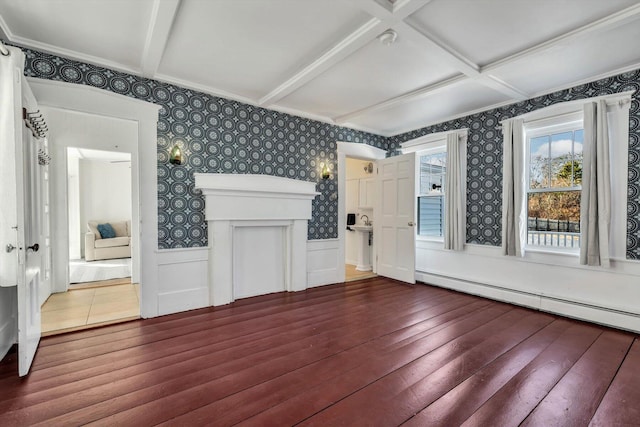 interior space with wood-type flooring, wainscoting, baseboard heating, and wallpapered walls