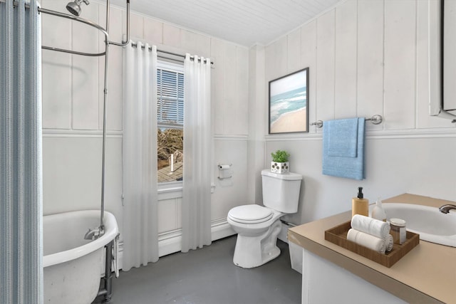 bathroom featuring concrete flooring, a freestanding bath, and toilet