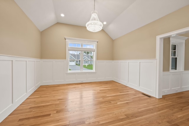 7 Nicklaus Way, Mashpee, MA 02649 - unfurnished dining area featuring a chandelier, a decorative wall, a wainscoted wall, light wood-type flooring, and lofted ceiling