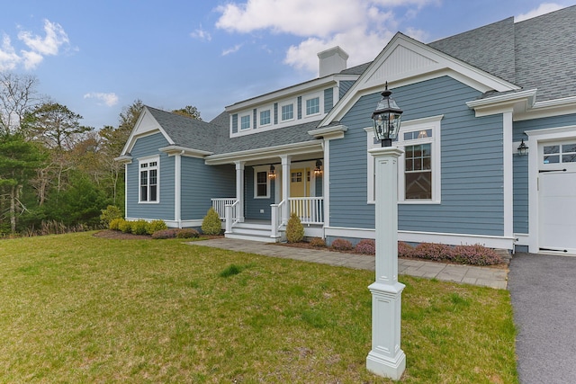 7 Nicklaus Way, Mashpee, MA 02649 - view of front of house with a porch, a chimney, a shingled roof, and a front lawn