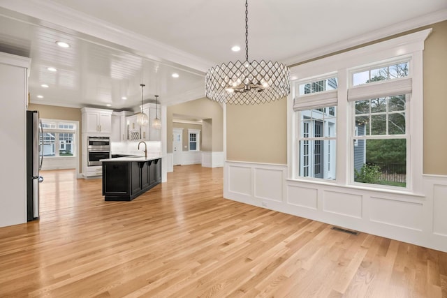 7 Nicklaus Way, Mashpee, MA 02649 - kitchen with a chandelier, light countertops, a decorative wall, crown molding, and stainless steel appliances