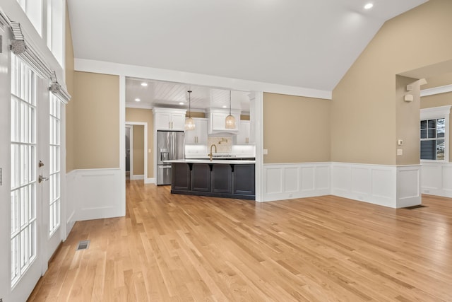 7 Nicklaus Way, Mashpee, MA 02649 - unfurnished living room with light wood-style flooring, a wainscoted wall, a decorative wall, recessed lighting, and a sink