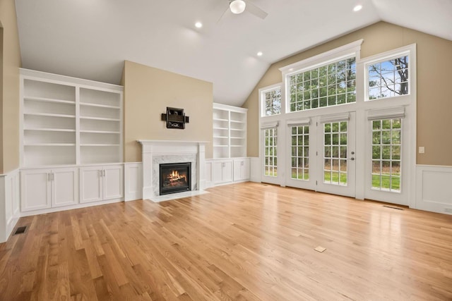 7 Nicklaus Way, Mashpee, MA 02649 - unfurnished living room with ceiling fan, vaulted ceiling, light wood finished floors, a high end fireplace, and a wainscoted wall