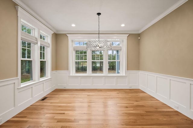 7 Nicklaus Way, Mashpee, MA 02649 - unfurnished dining area with crown molding, a chandelier, a wainscoted wall, light wood finished floors, and a decorative wall