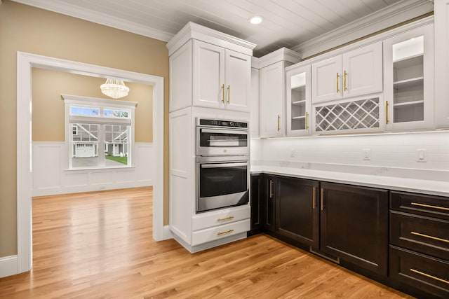 7 Nicklaus Way, Mashpee, MA 02649 - kitchen featuring double oven, white cabinetry, light countertops, a chandelier, and crown molding