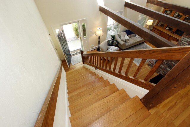 473 Thousand Oaks Dr, Brewster, MA 02631 - staircase featuring wood finished floors, a towering ceiling, and baseboards