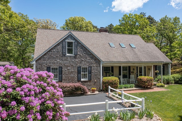 473 Thousand Oaks Dr, Brewster, MA 02631 - cape cod-style house with a porch, a chimney, a front yard, and a shingled roof