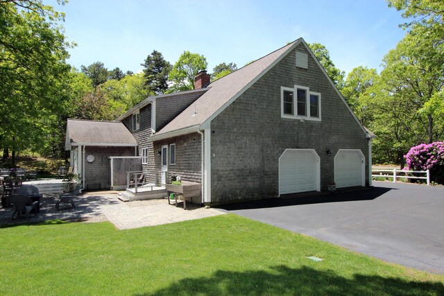 473 Thousand Oaks Dr, Brewster, MA 02631 - back of property featuring a chimney, a shingled roof, a patio, and a garage