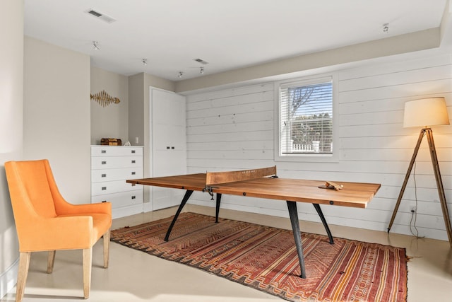 interior space featuring concrete floors and wooden walls