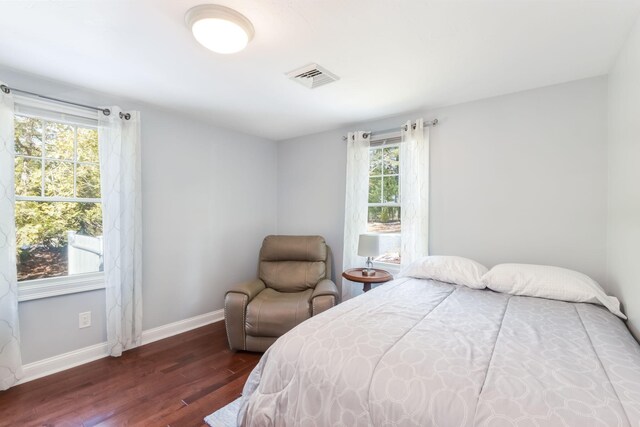 bedroom featuring visible vents, baseboards, and wood finished floors