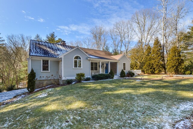 single story home featuring a front yard, a porch, roof with shingles, and a chimney