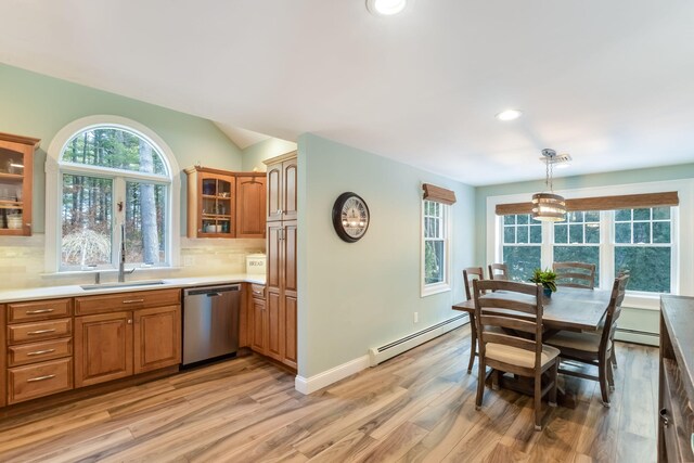 kitchen with backsplash, a baseboard heating unit, dishwasher, light countertops, and a sink