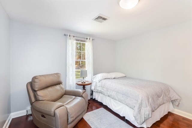 bedroom featuring visible vents, baseboards, and dark wood-style flooring