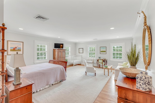 bedroom featuring multiple windows, ornamental molding, and light hardwood / wood-style flooring