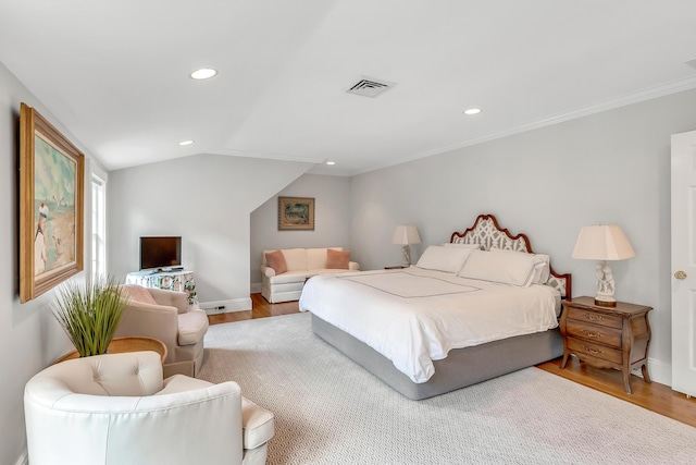 bedroom featuring ornamental molding, vaulted ceiling, and hardwood / wood-style floors