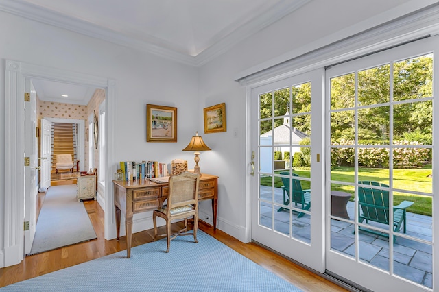 doorway to outside with crown molding and light wood-type flooring